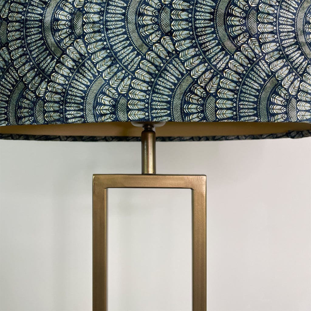 Lamp with decorative blue and gold patterned shade and brass base.