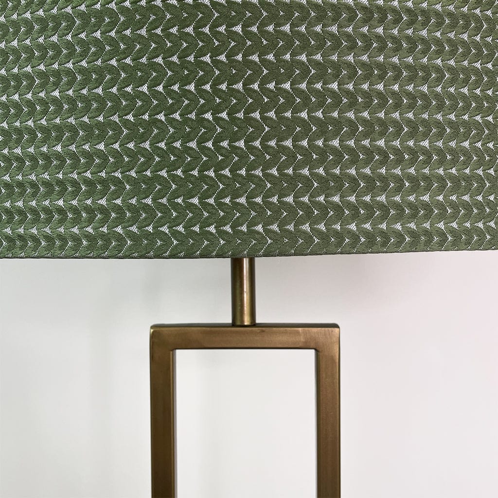 Lamp with green patterned shade and bronze base on a white background