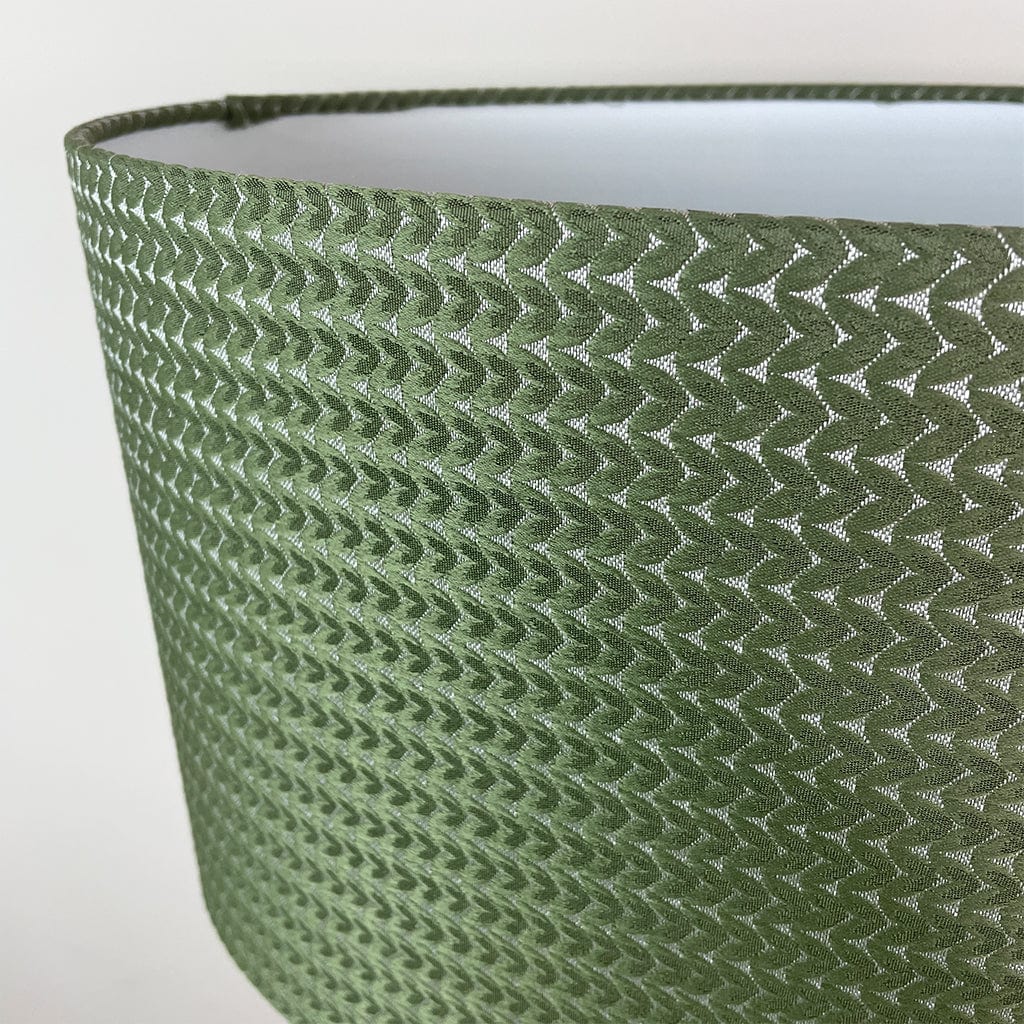 Close-up of a green textured fabric lampshade on a white background