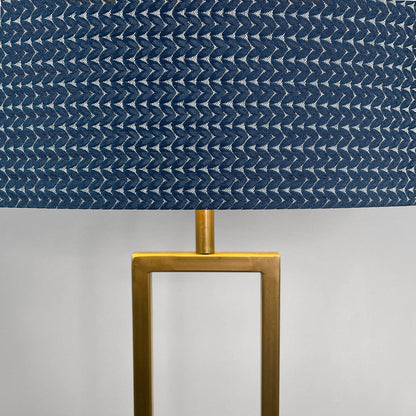 Lamp with a blue patterned shade and gold base on a gray background