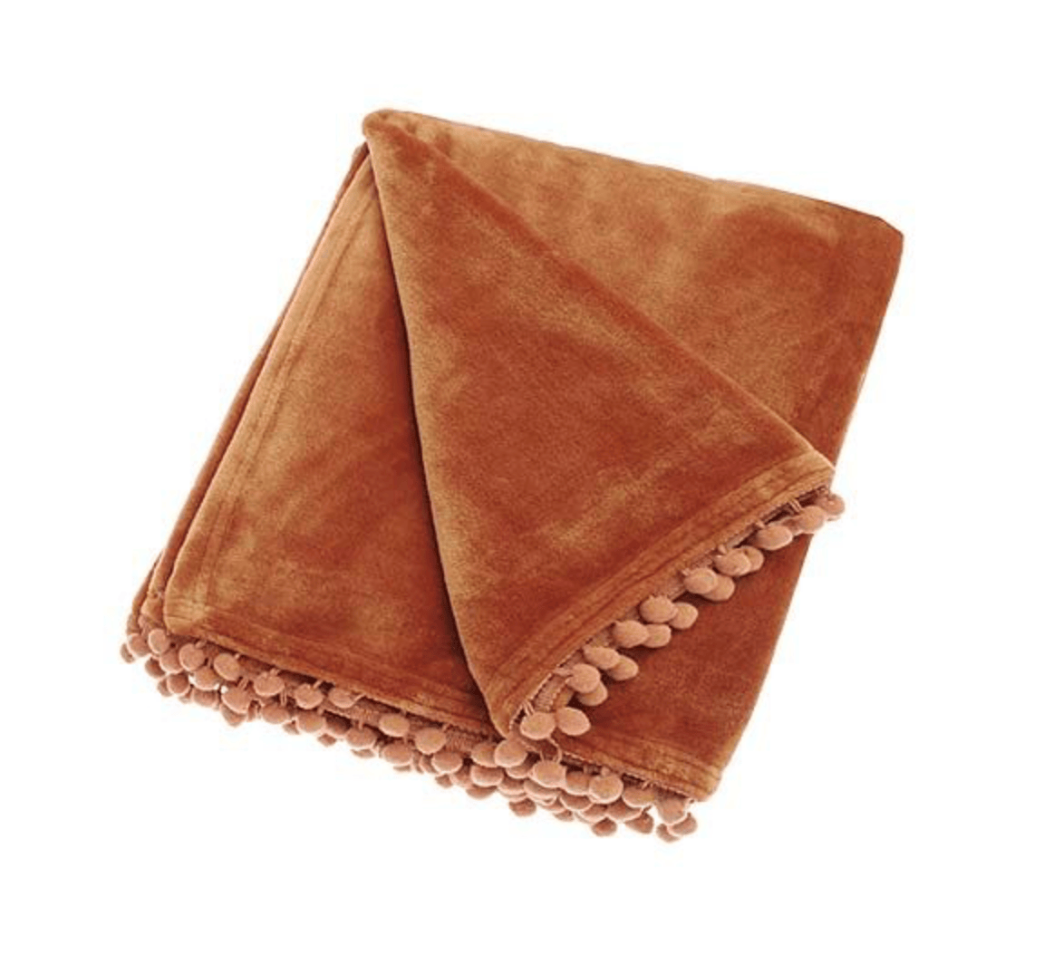 Spice Orange plush blanket with pom-pom trim on a white background