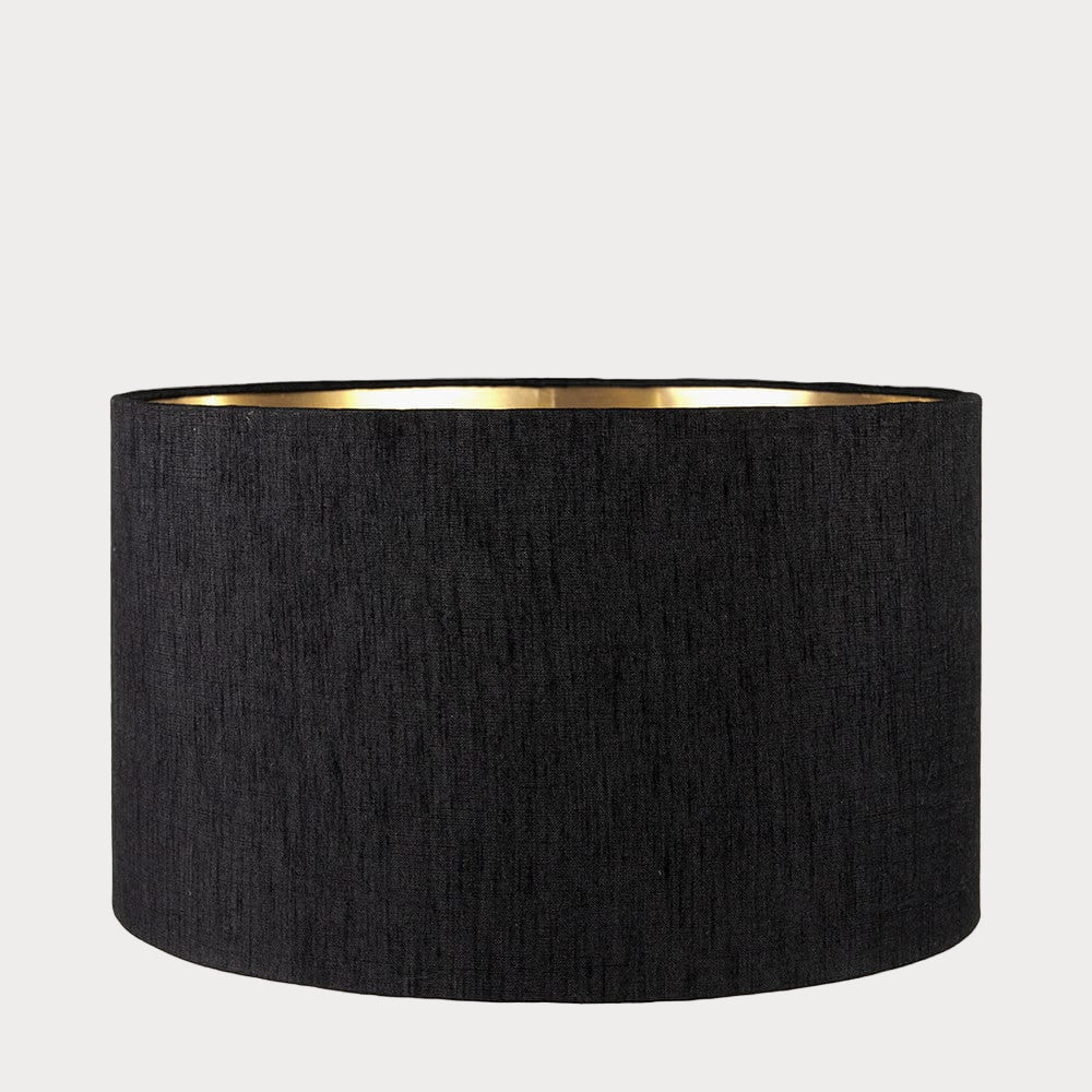 A cylindrical lampshade with a slubbed faux silk texture and a gold interior lining.