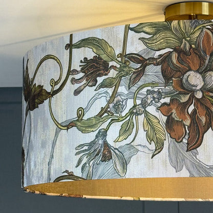Floral-patterned lampshade with gold trim against a dark background