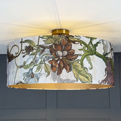 Floral patterned lampshade with gold trim on a ceiling light fixture.