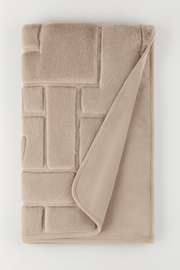 Beige soft throw with textured pattern on a white background