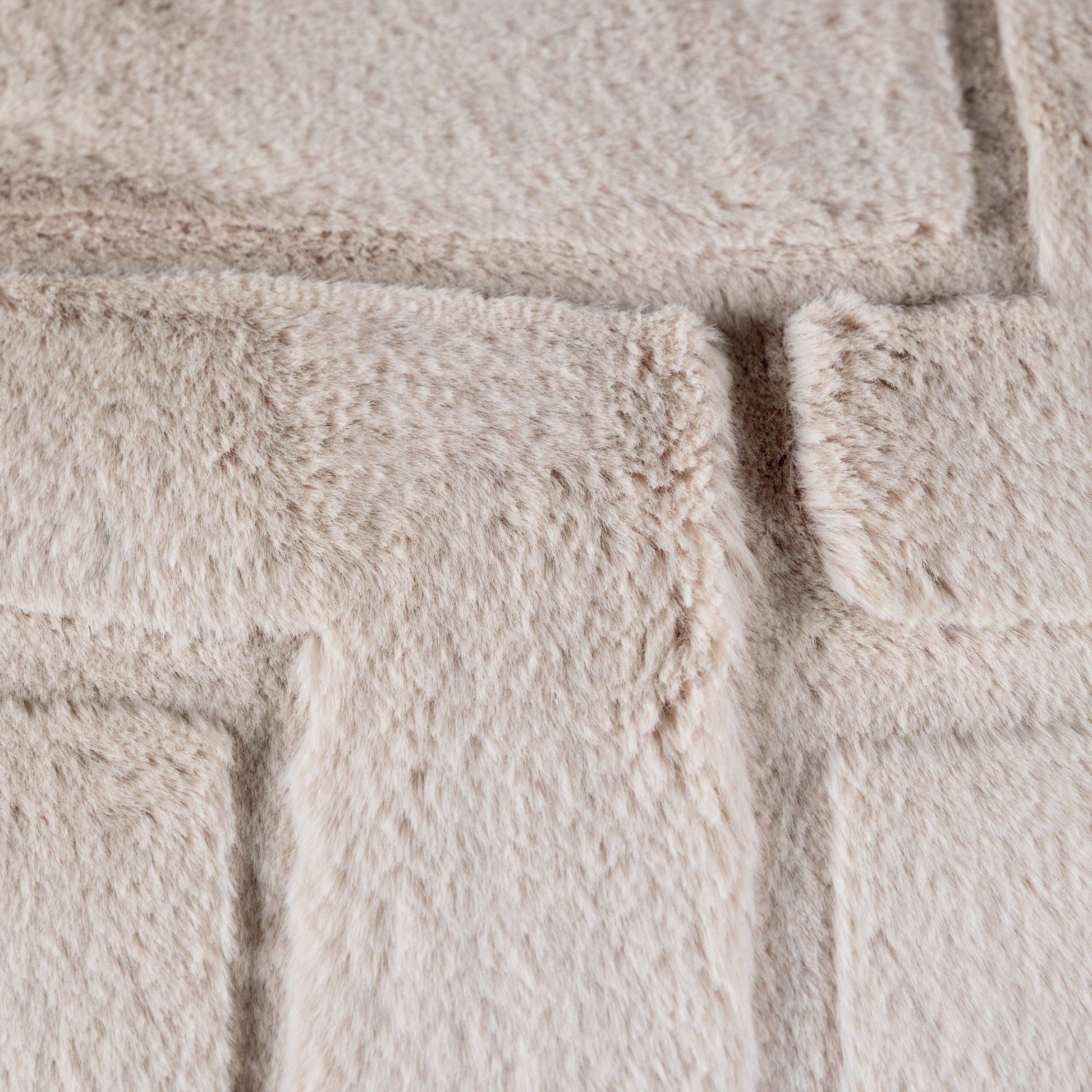 A close up of a soft fluffy beige cushion