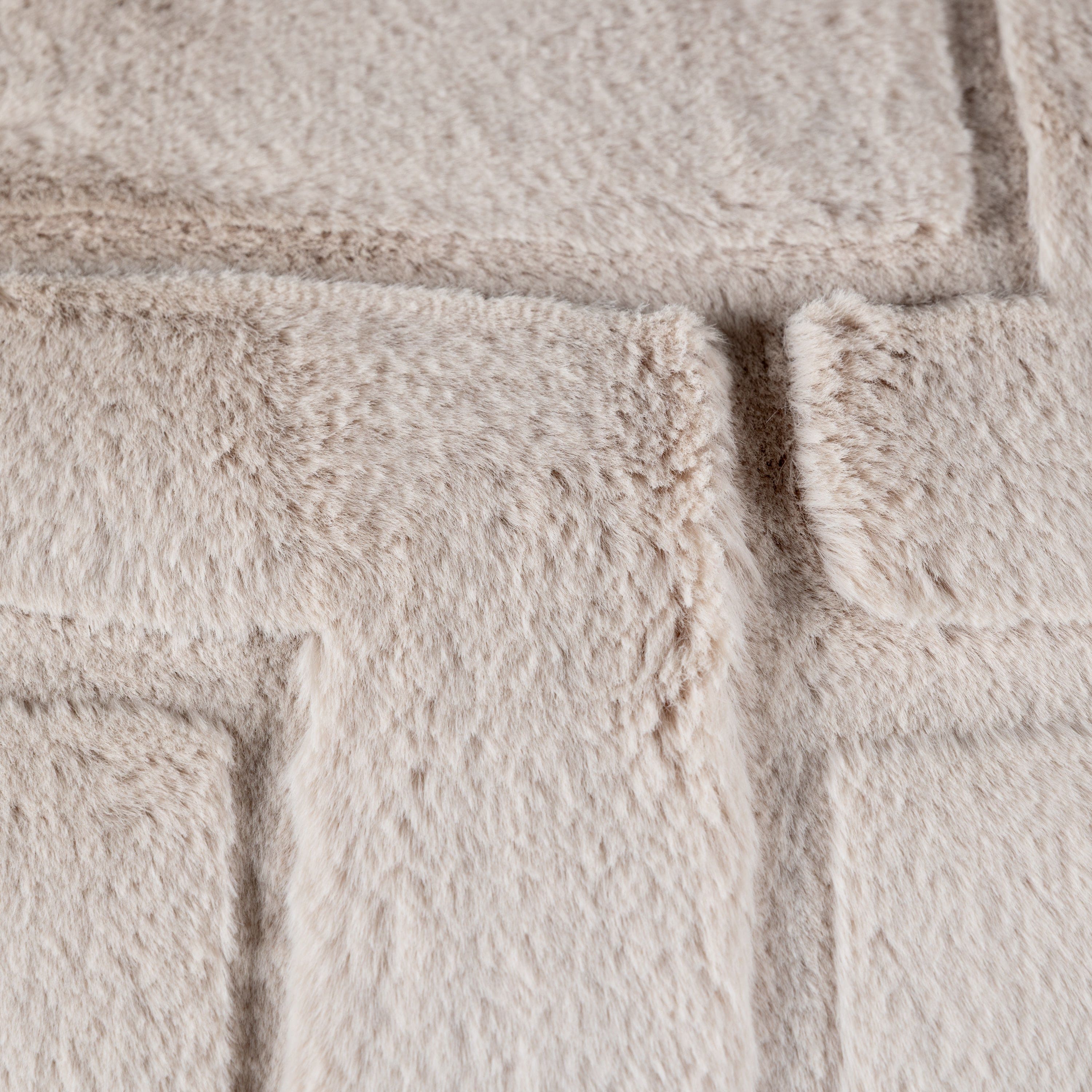 A close up of a soft fluffy beige cushion