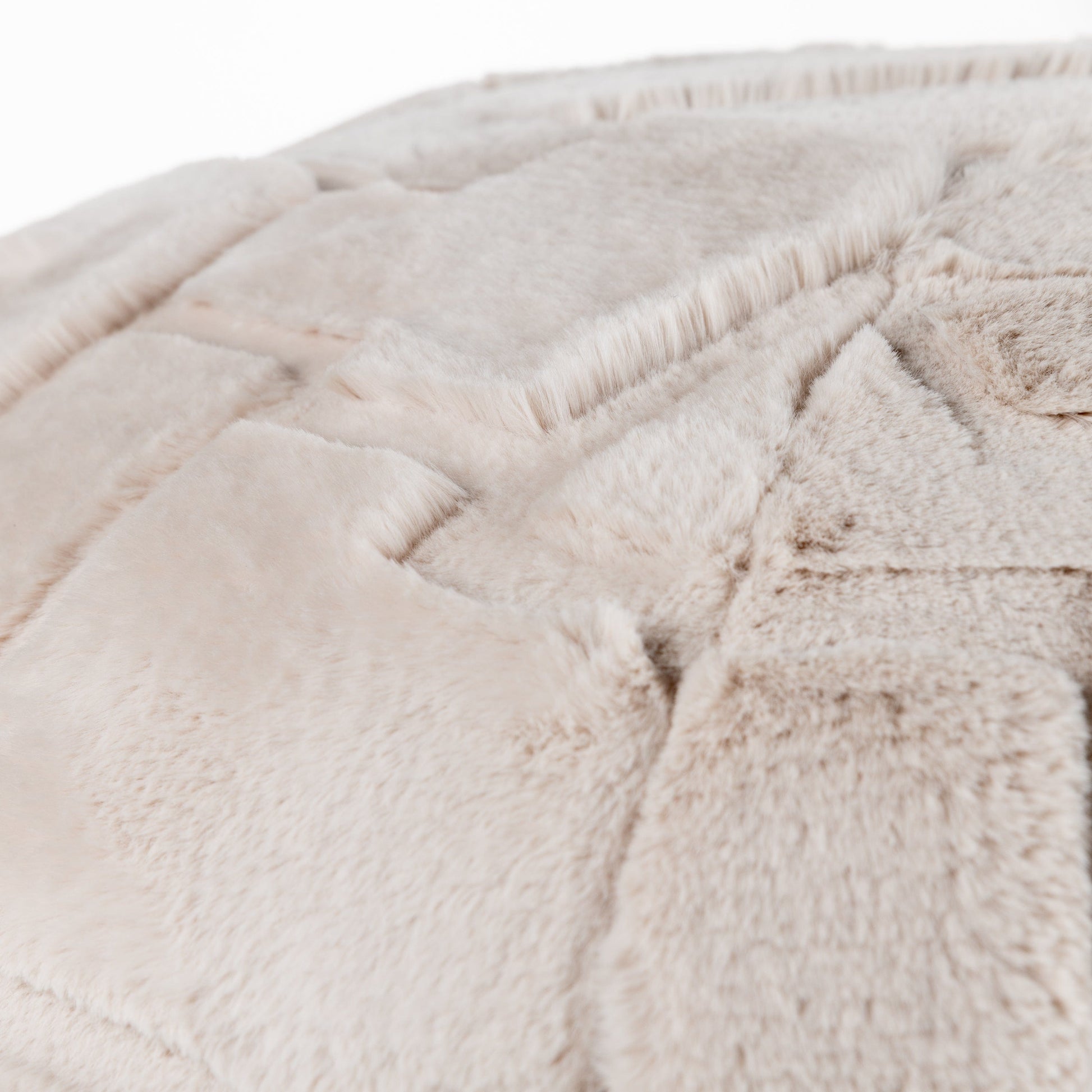 Close-up of the textured beige fabric surface of the Toni cushion pod which is soft and geometric in style