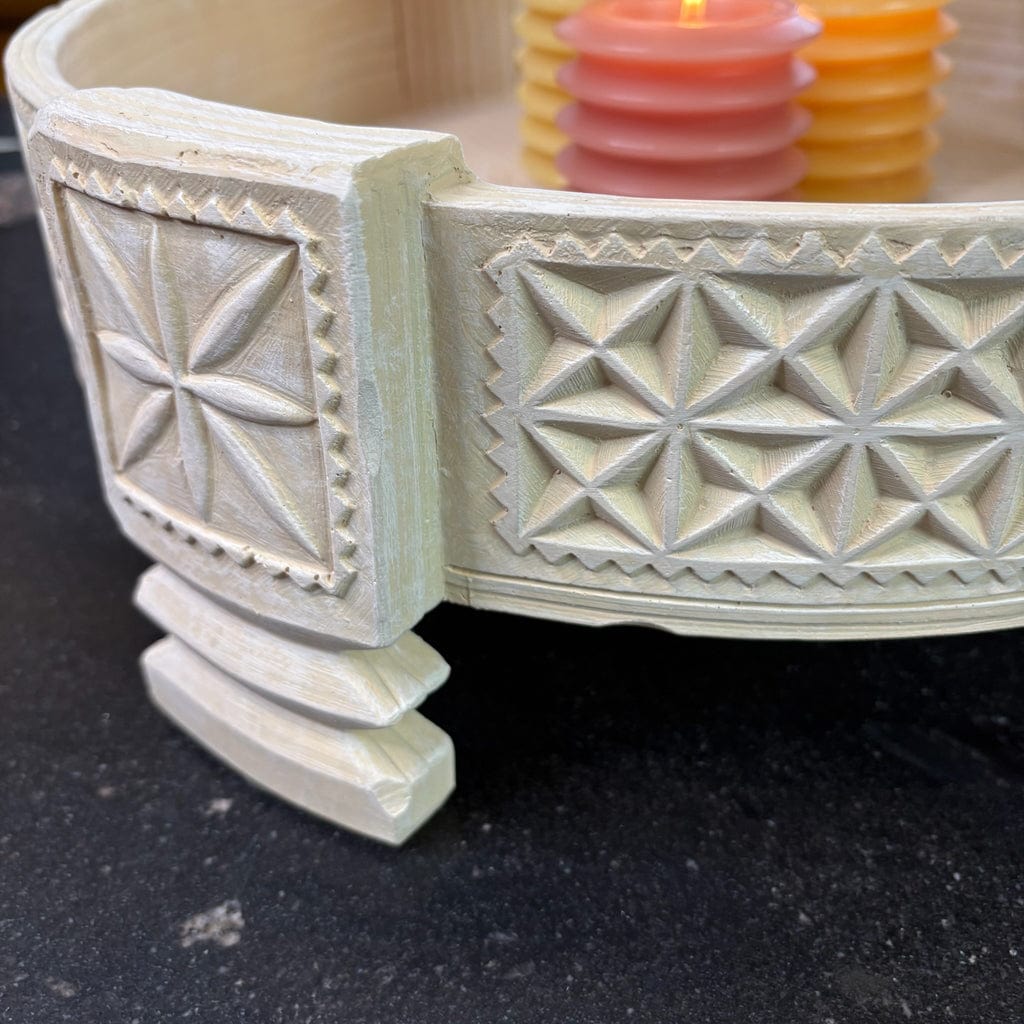Decorative white ceramic planter with geometric patterns on a dark surface
