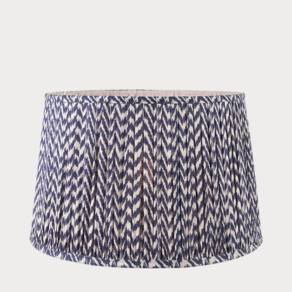 A tapered lamp shade with a zigzag pleated design in a blue and white color scheme.