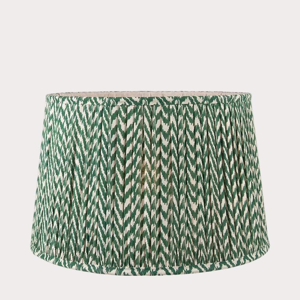 A tapered lamp shade with a zigzag pleated design in a green and white color scheme.