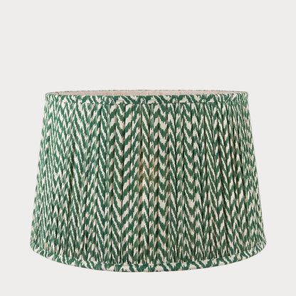 A tapered lamp shade with a zigzag pleated design in a green and white color scheme.
