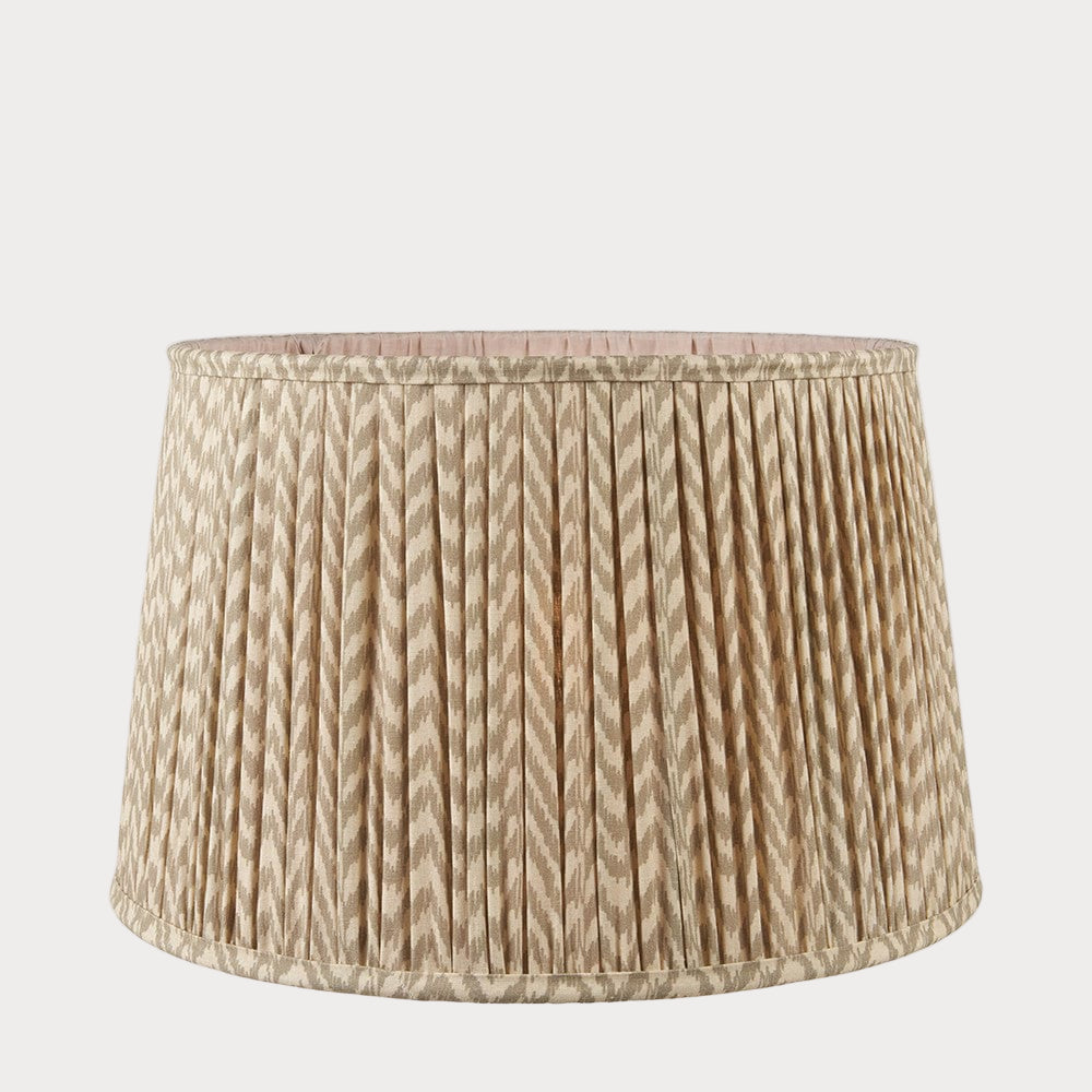A tapered lamp shade with a zigzag pleated design in a taupe and white color scheme.