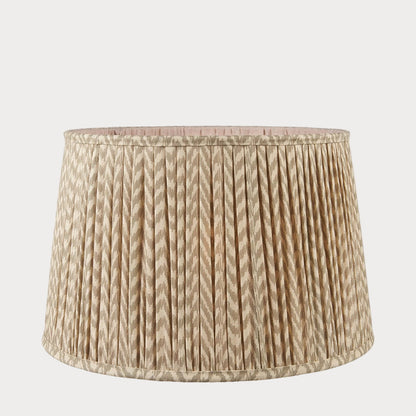 A tapered lamp shade with a zigzag pleated design in a taupe and white color scheme.