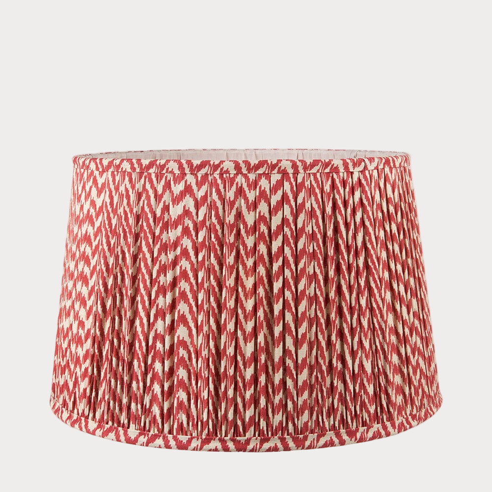 A tapered lamp shade with a zigzag pleated design in a red and white color scheme.