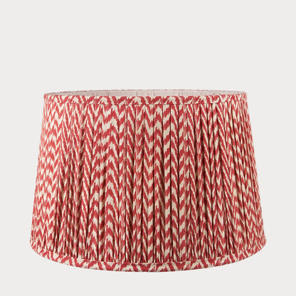 A tapered lamp shade with a zigzag pleated design in a red and white color scheme.