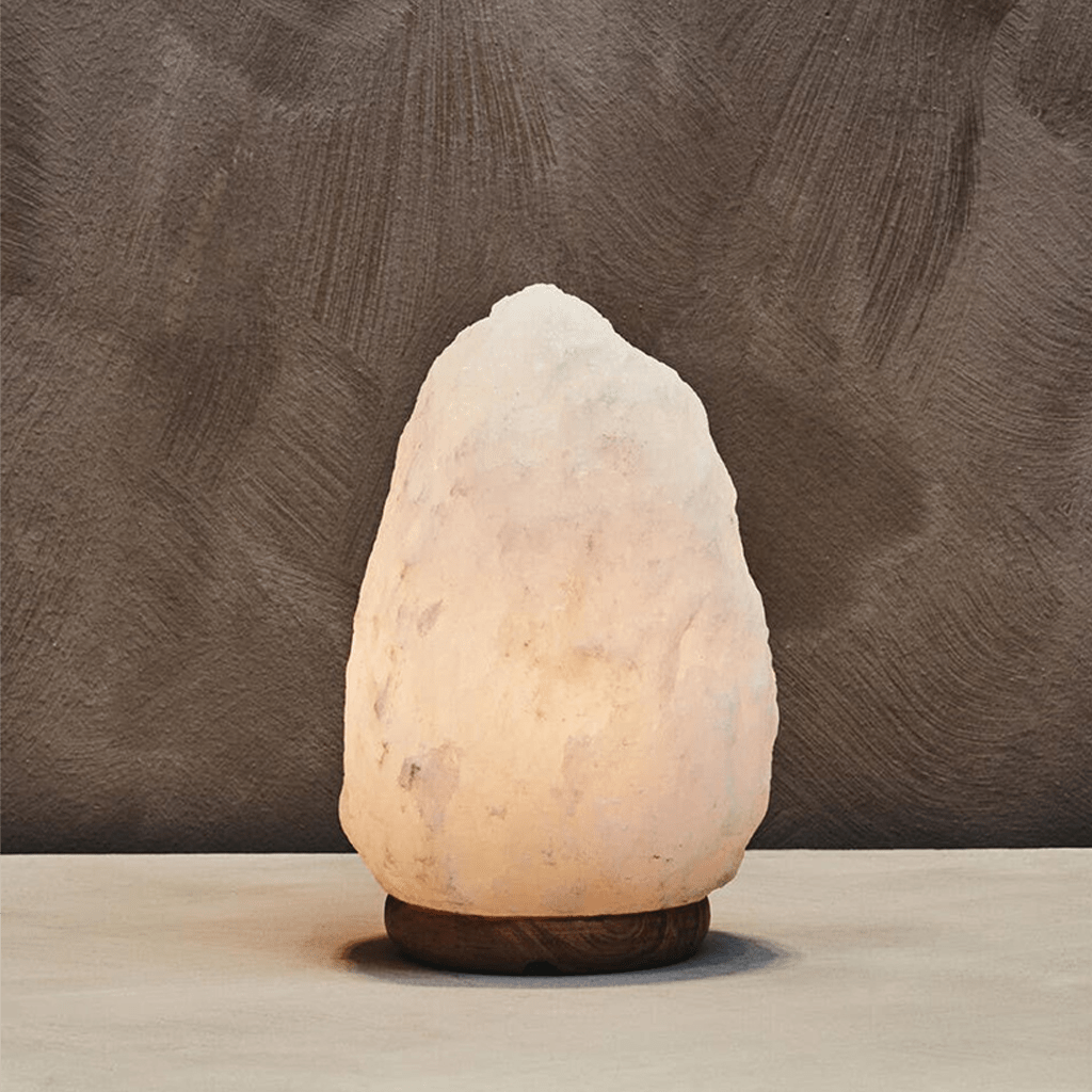 Rock-shaped salt lamp on a wooden surface with a brown textured background