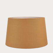 A tapered cylinder shade made of mustard cotton, displayed on a plain background.
