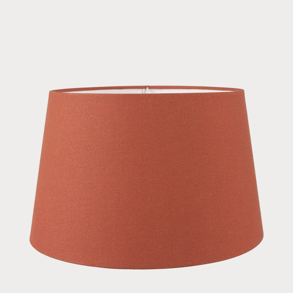 A orange tapered cylinder lampshade made of cotton, designed for use with various lamp bases.