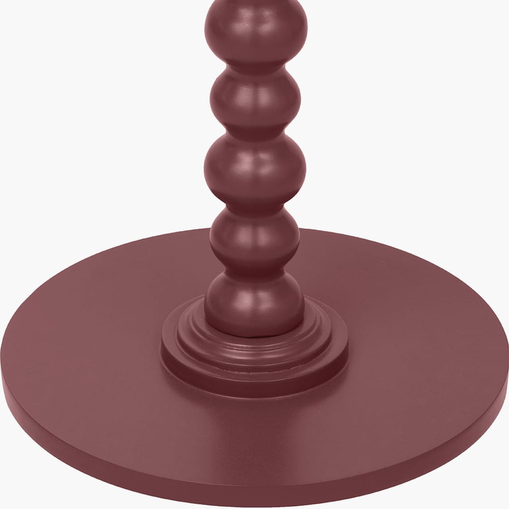 Maroon candle holder with a round base and cylindrical design on a white background