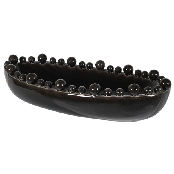 An elongated black ceramic bowl with a glossy finish and bobbled texture along the rim.