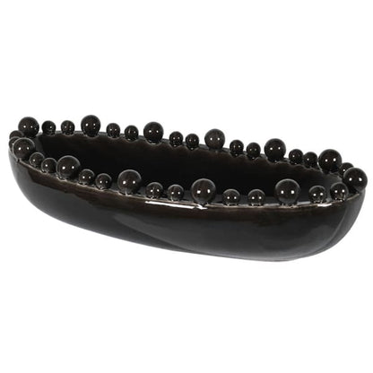 An elongated black ceramic bowl with a glossy finish and bobbled texture along the rim.