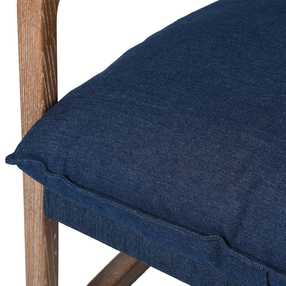 Close up of a blue denim material and wooden frame of a chair