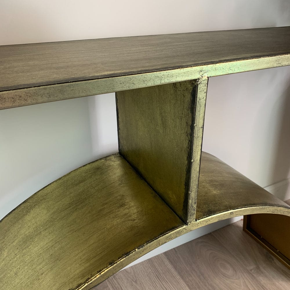 Metal console table in gold on a white background