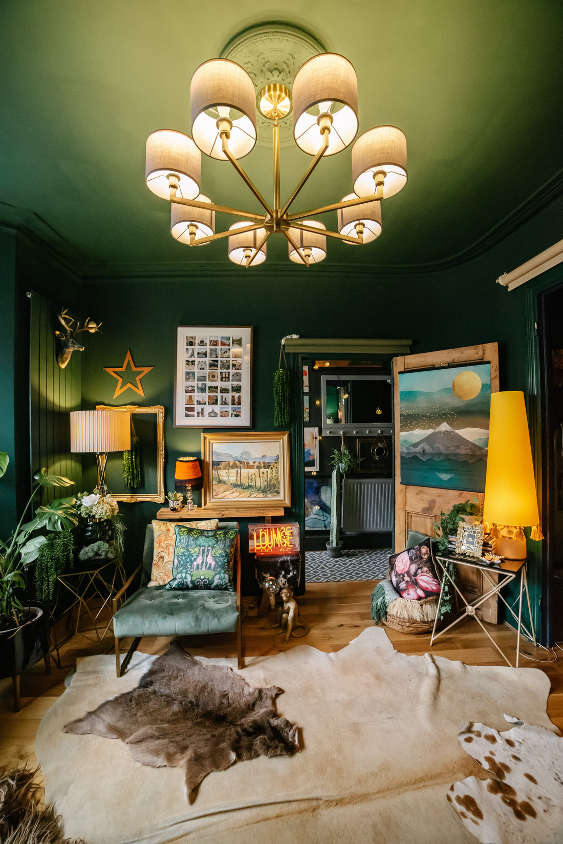Living room with a chandelier, green walls, and various decor items.