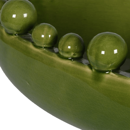 Close-up of green peas in a pod with water droplets on a green background