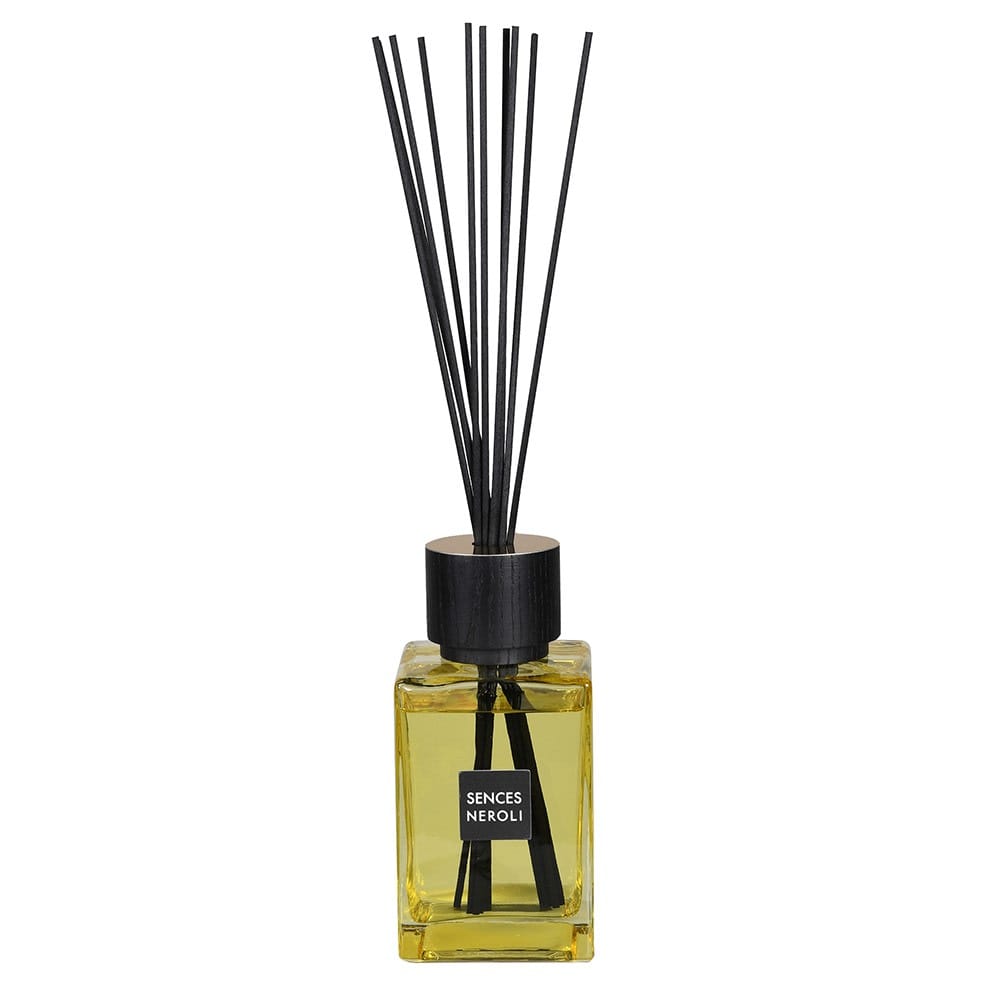 A yellow reed diffuser with black reeds